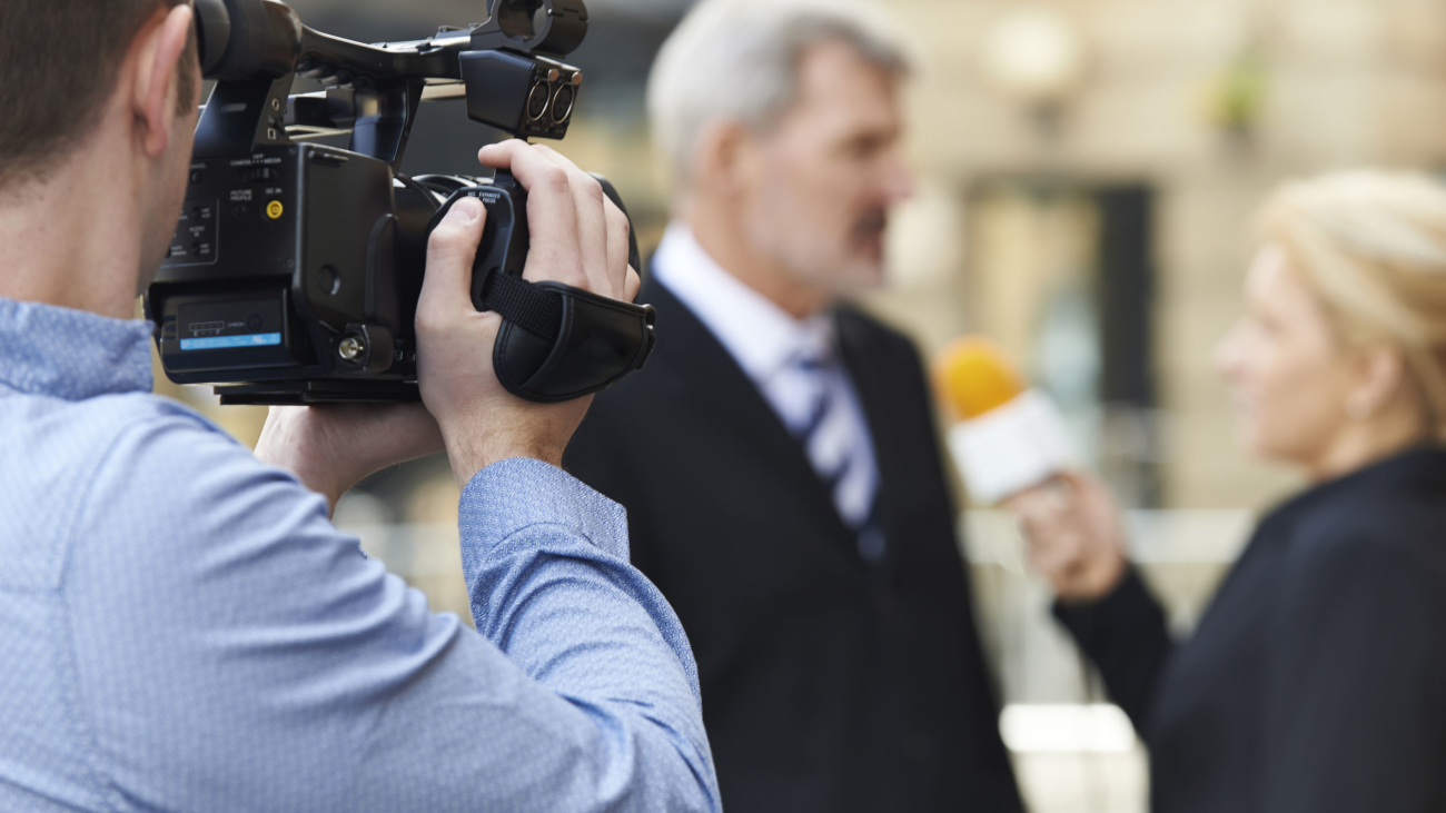 Cameraman Recording Female Journalist Interviewing Businessman